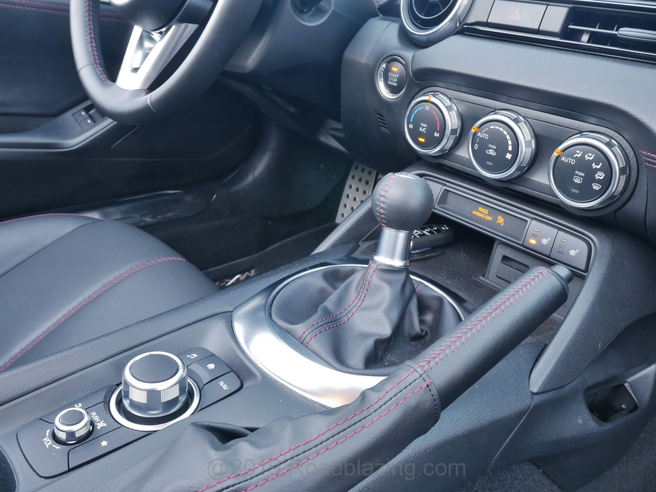 2019 Mazda MX-5 Grand Touring: Center console dominated by 6-speed manual transmission short throw shifter, now with dual mass flywheel, and machined alloy i-Connect infotainment Commader twist / toggle dial and twist audio volume dial.
