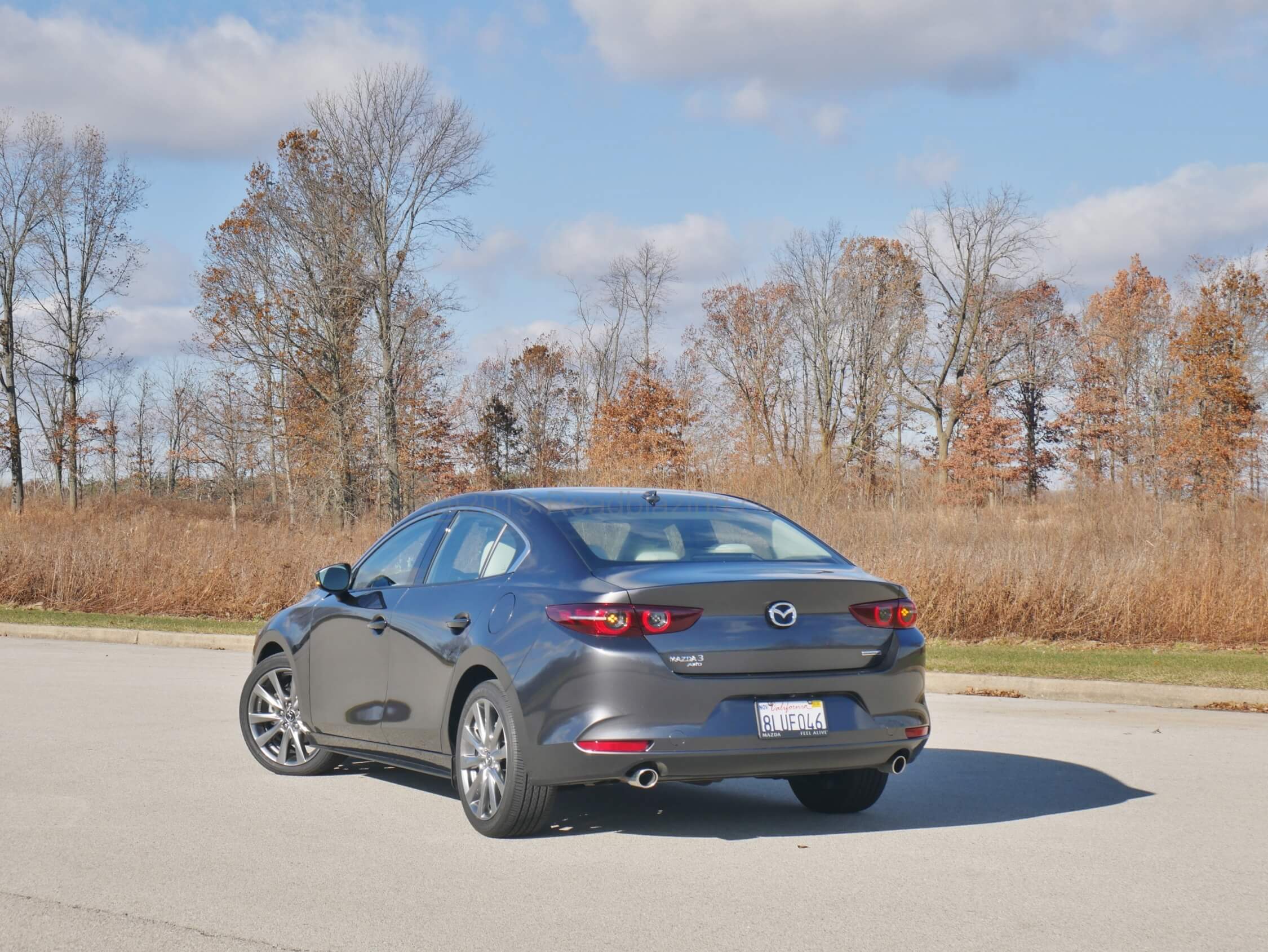 2020 Mazda 3 sedan awd premium: sharing heritage with the MX-5 results in adoption of smooth bevel trunk lid w/ ducktail edge and circular directional taillamps with wrap around arrows.